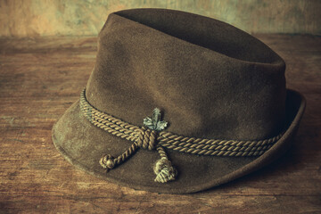 An old hunter's hat is lying on a wooden table.Vintage brown headdress made of fabric.