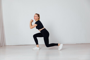 Obraz premium a woman does exercise warm-up exercises in the gym