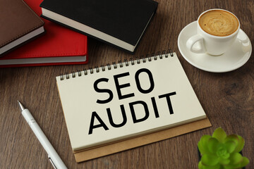 text SEO AUDIT. on paper. potted plant next to notebook