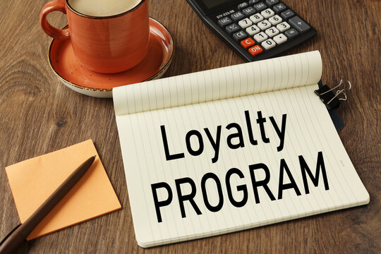 loyalty program. open notepad near calculator and cup of coffee