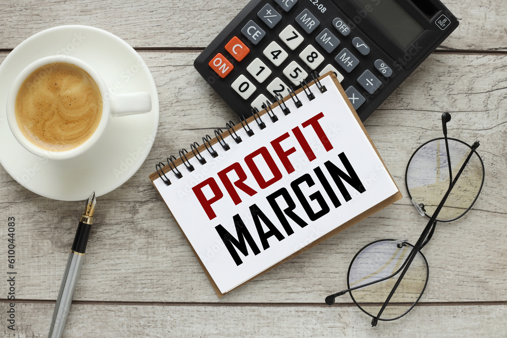 Poster profit margin calculator and a cup of coffee. work desk with text on notepad
