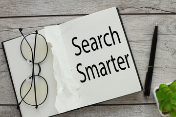Search Smarter notepad with text. glasses on a notebook page.