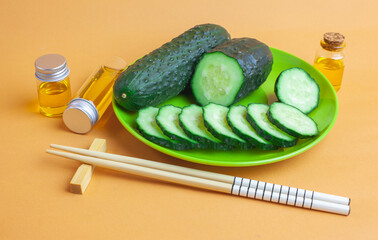 Pepino fresco sobre un plato de plástico verde y junto a unos palillos chinos