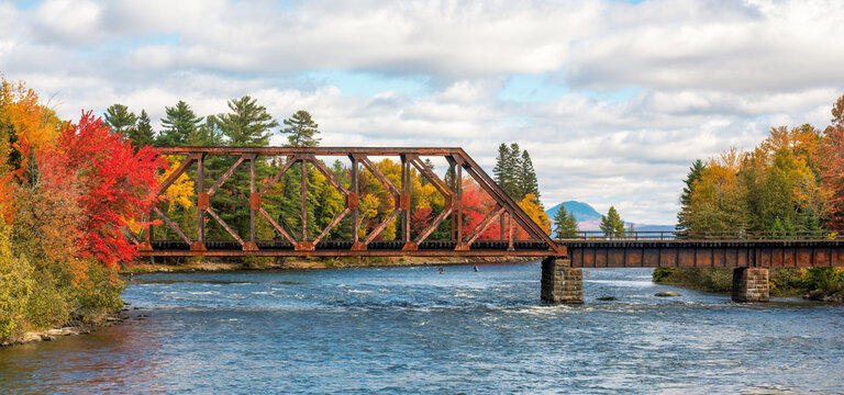 Autumn colors on the river at Moosehead Lake, Maine - train trestle