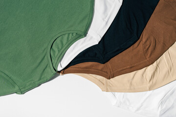 T-shirts of different colors laid out on a white isolated background close-up. Image for your...
