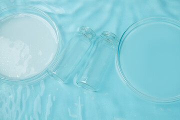 Naklejka premium Set of laboratory utensils empty Petri dish, flasks, jars on the background of blue water
