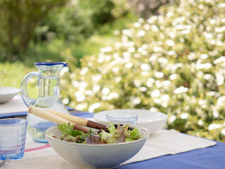 Healthy eating summer, salad beside a glass pitcher of cool water. Outdoor meals.