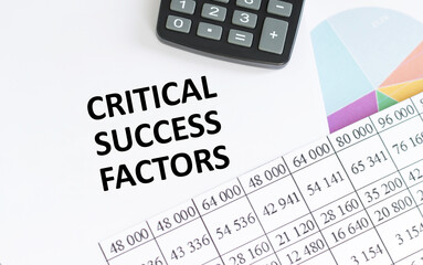 financing availabe text concept. Office workplace table with calculator, graphs, reports and the text CRITICAL SUCCESS FACTORS