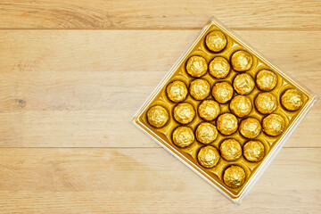 golden premium chocolate sweets box on wood table for holidays