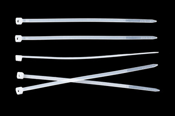 White plastic cable ties isolated on black background. plastic wire ties close up.