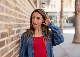 Fototapeta premium pretty woman looking happy, listening, trying to hear a secret conversation or gossip, eavesdropping