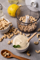 Fototapeta na wymiar Cashew nut cream cheese in a white bowl and cooking ingredients