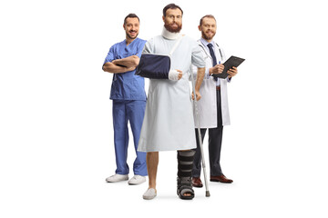 Team of doctors and a male patient with an orthopedic boot and cervical collar in a hospital gown