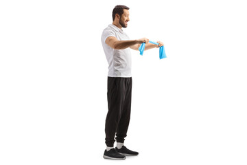 Full length profile shot of a fitness coach exercising with a resistance band