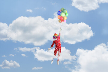 Funny clown holding a bunch of balloons and flying up