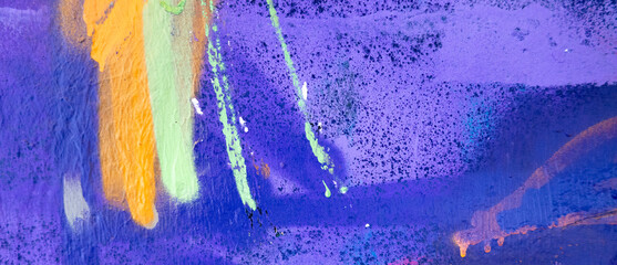 Purple, pink, magenta, white, yellow painted grunge plaster wall surface background with colorful drips, flows, streaks of paint and paint sprays