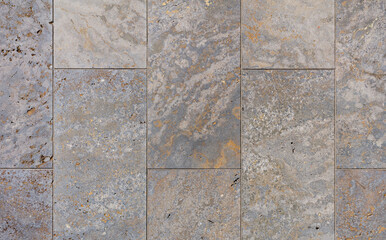 texture of a tiled brown stone wall as background, natural stone wall texture as background. Close-up of a wall clad in limestone