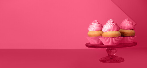 Stand with delicious cupcakes on magenta background with space for text
