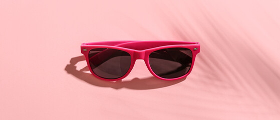 Stylish sunglasses on pink background