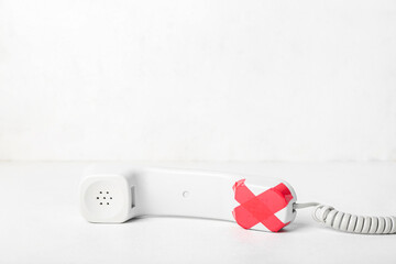 Taped phone receiver on white background. Censorship concept