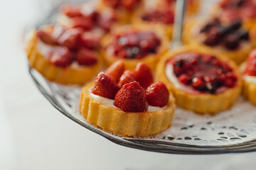 Close-up of small delicious berry tarts on a white background