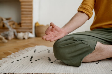 Indoor meditation concept, closeup view on male hand in gyana mudra
