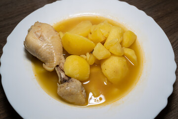 Homemade potato soup with chicken drumsticks in a white plate 