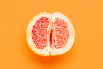 Fototapeta Half of grapefruit on orange background. Sex concept obraz