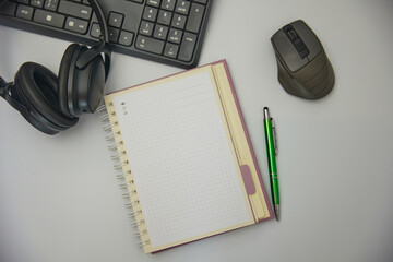 Top view of a white office desk with a notebook