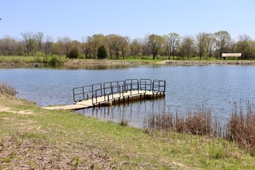 The small dock at the lake on a sunny day.