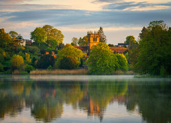 Fototapeta premium Sunset view of town of Ellesmere in Shropshire with reflection view across the Mere to the Church