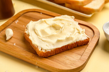 Tasty toast with cream cheese on yellow background