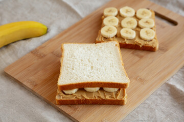 Fototapeta na wymiar Homemade Peanut Butter Banana Sandwich on a Bamboo Board, side view.