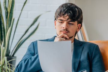 young man or student at home thoughtful looking at the document