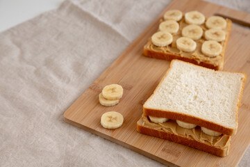 Homemade Peanut Butter Banana Sandwich on a Bamboo Board, side view. Copy space.