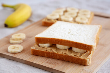 Homemade Peanut Butter Banana Sandwich on a Bamboo Board, side view. Copy space.