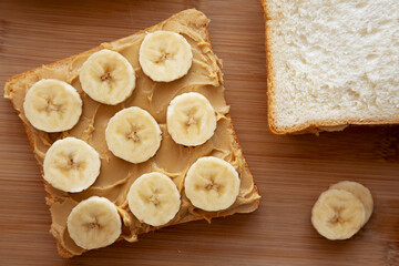 Homemade Peanut Butter Banana Sandwich on a Bamboo Board, top view. Overhead, from above, flat lay.