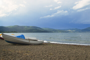 boats on the beach with mountains in background in Italy
