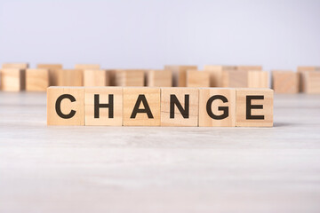 word CHANGE inscribed on wooden cubes lying on a light table. economy and investments concept.