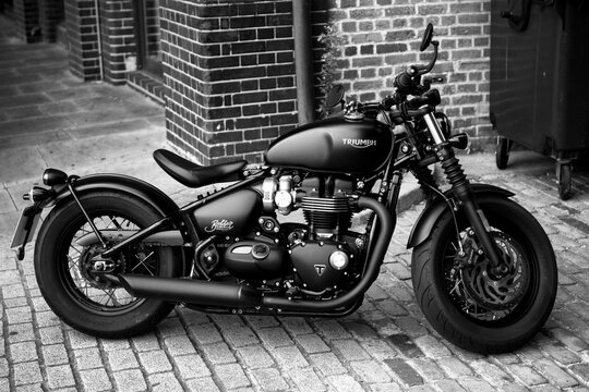 Grayscale shot of a parked Triumph Bonneville Bobber Motorcycle