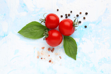 Composition with ripe cherry tomatoes, sea salt and peppercorn on blue background