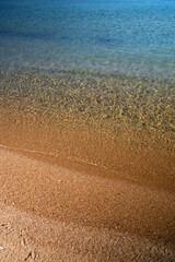 Close up of the beautiful sandy beach and the crystal clear waters of Kalamos in Ios Greece