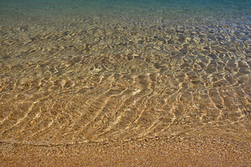 Close up of the beautiful sandy beach and the crystal clear waters of Kalamos in Ios Greece