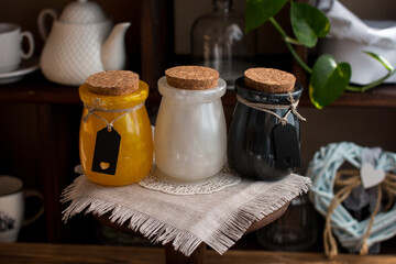 Spice jars of different colors in a wooden box on a shop window. The concept of rustic European style, home comfort