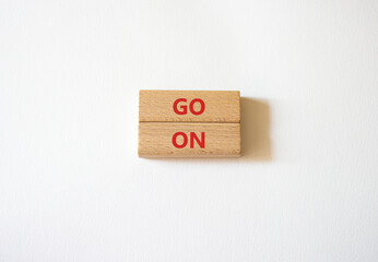 Go on symbol. Wooden blocks with words Go on. Beautiful white background. Business and Go on...