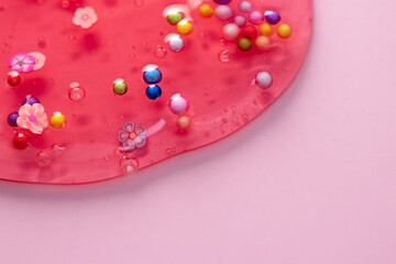 Colorful gel texture, clear skincare cream with bubbles and decorative figurines background, transparent beauty serum, colored cosmetic product close up