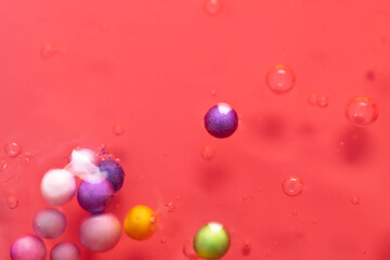 Colorful pink gel texture with bubbles, clear skincare cream with bubbles and decorative figurines background, transparent beauty serum, colored cosmetic product close up