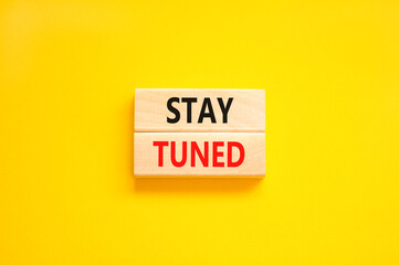 Stay tuned symbol. Concept words Stay tuned on wooden blocks on a beautiful yellow table yellow background. Business, support, motivation, psychological and stay tuned concept. Copy space.