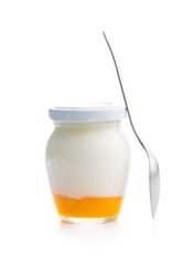 Fruity yogurt in jar and spoon isolated on white background.