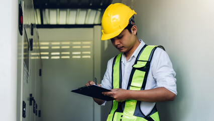 Electrical engineer working in control room. Electrical engineer man checking Power Distribution Cabinet in the control room